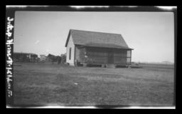 Small Home with an Enclosed Porch, Horse and Buggy in Back