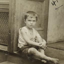 Boy Sitting at Entrance to ...